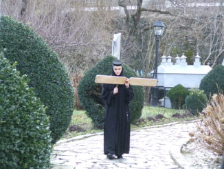 Een non roept de gelovigen op naar de dienst (foto: Casper Schaaf)